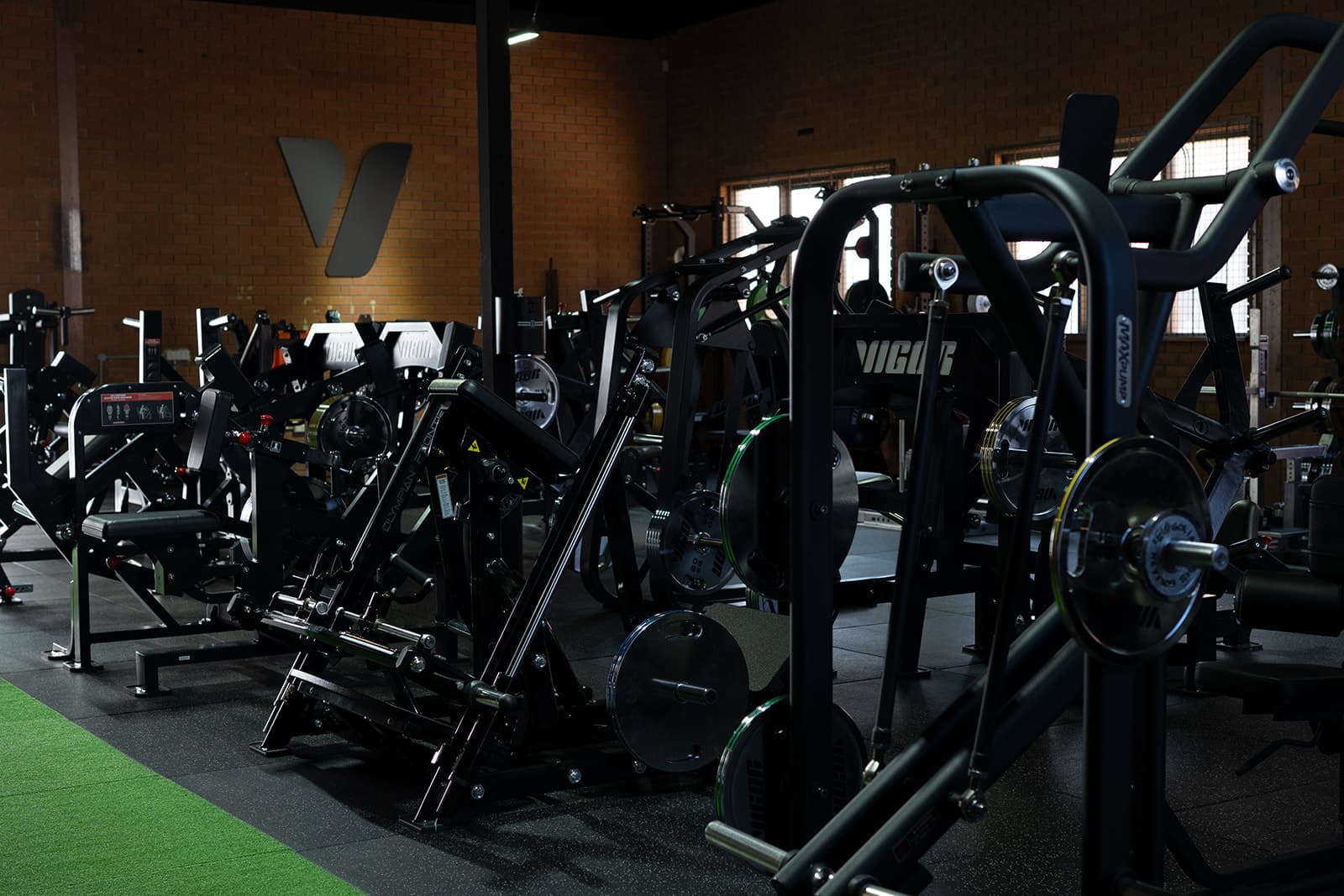 Rows of black plate-loaded strength machines on the Vigor HQ gym floor