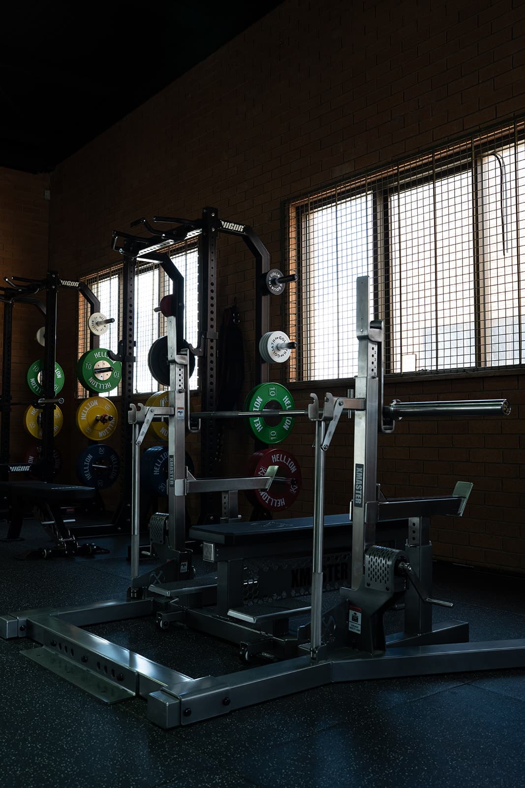 XMASTER combo racks and benches set up with barbells and weight plates